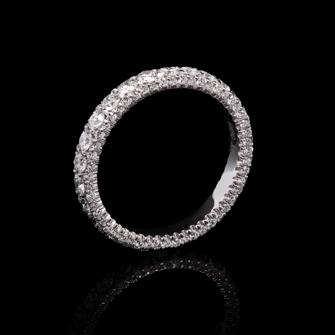 Three-sided platinum band adorned with lab-grown diamonds. (Stardust Eternity Ring). Shown on black background.