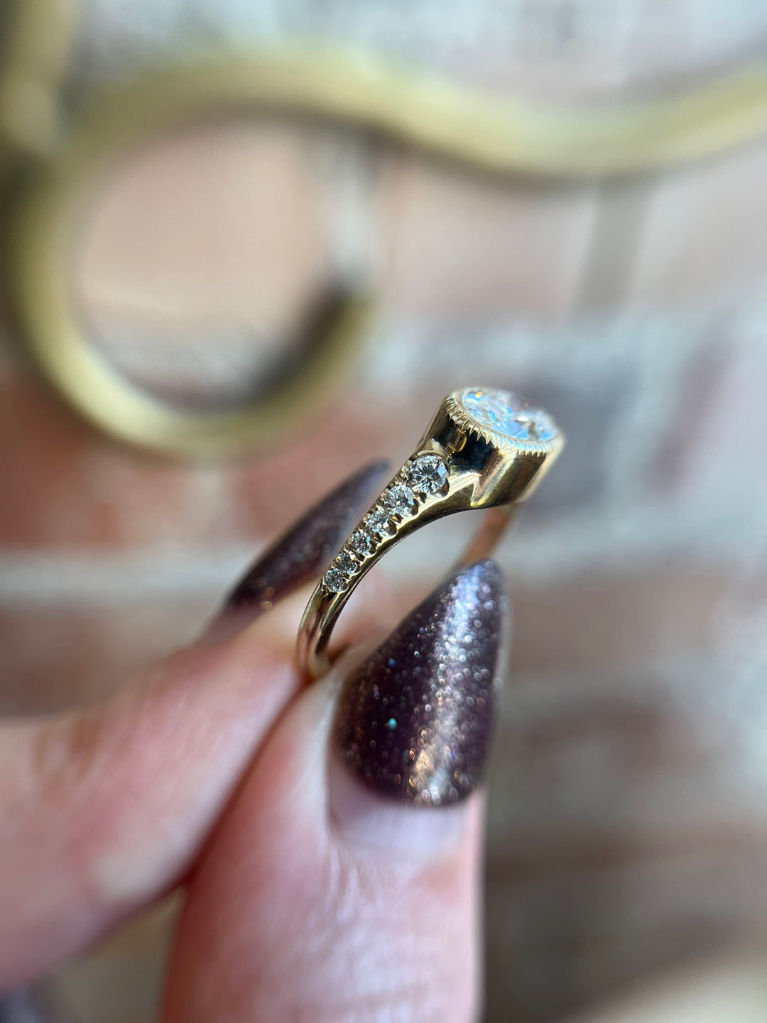 Oval diamond engagement ring in yellow gold, worn on hand, fine jewellery by Toronto artisan Janine Jewels.