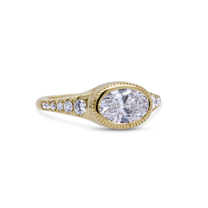 Side angle of oval diamond ring in 18K yellow gold with pavé side stones, fine engagement jewellery by Janine Jewels.
