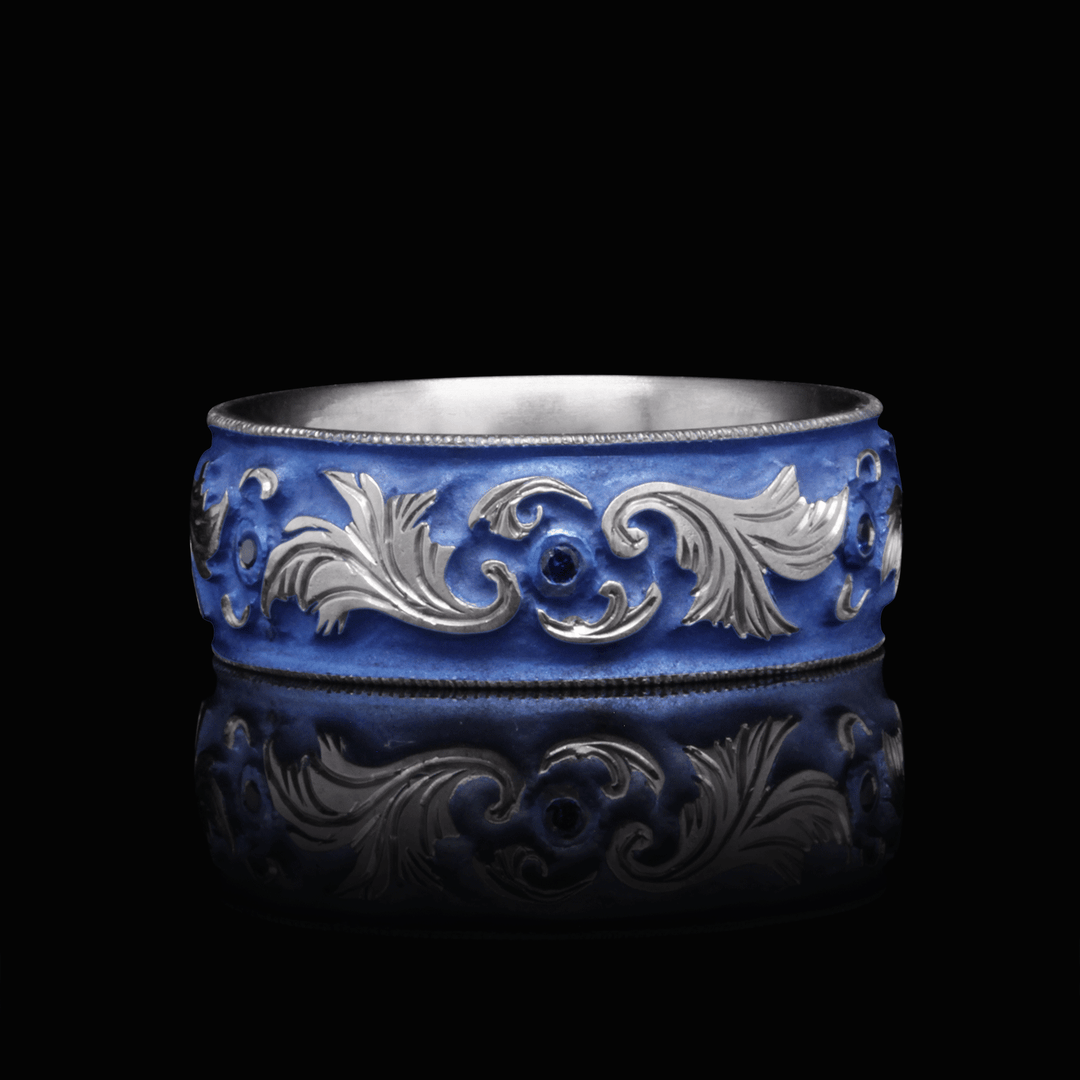 8mm blue anodized titanium ring with intricate scroll engraving and lab-grown blue sapphires, highlighted against a black background, size 9.25.