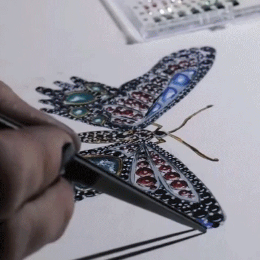 Sabrina, hand-painting a jewellery design of a brooch paved with different gemstones