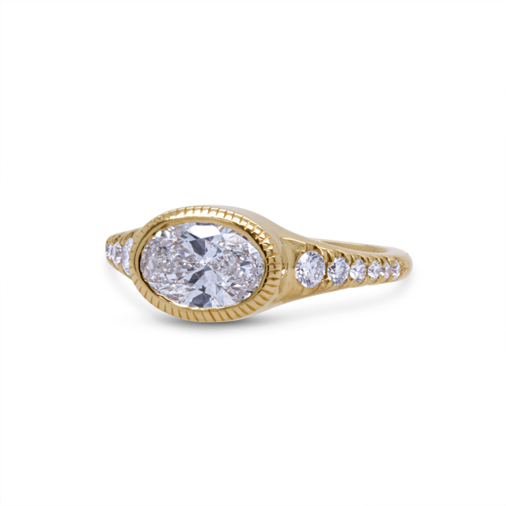 18K yellow gold oval diamond engagement ring with milgrain detailing and accent diamonds, angled perspective.