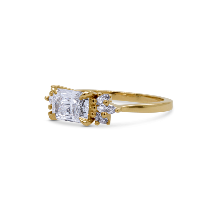 14K yellow gold radiant diamond engagement ring with marquise and round side stones, angled studio shot.