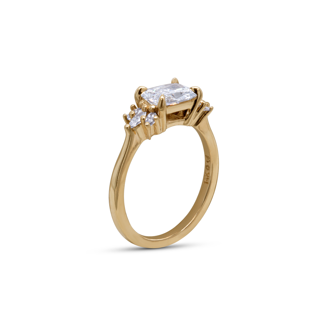 Profile of radiant cut lab diamond engagement ring in 14K yellow gold with pavé-set marquise and round diamonds.