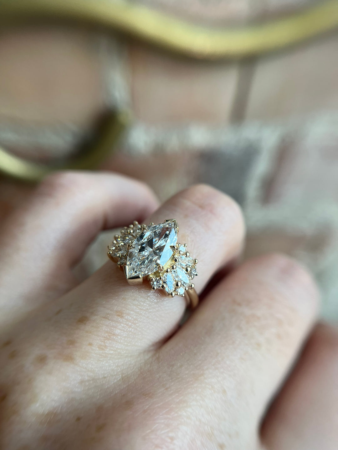 Clara marquise diamond engagement ring in yellow gold with accent diamonds, worn on hand, Toronto-made by Janine Jewels