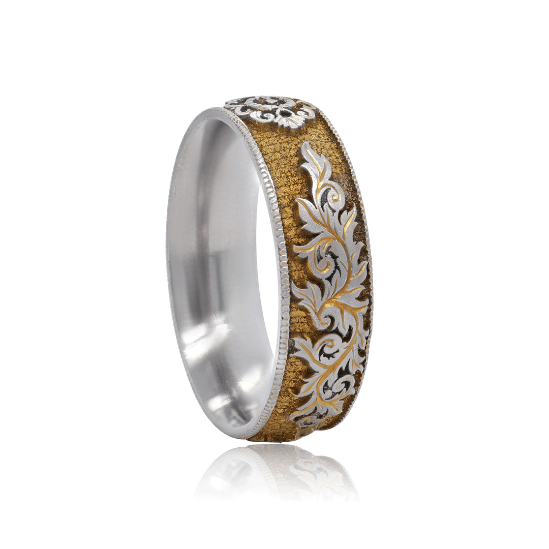 Angled view of titanium ring with gilded gold finish, detailed lock and scroll engraving, and intricate craftsmanship, displayed against a white background.