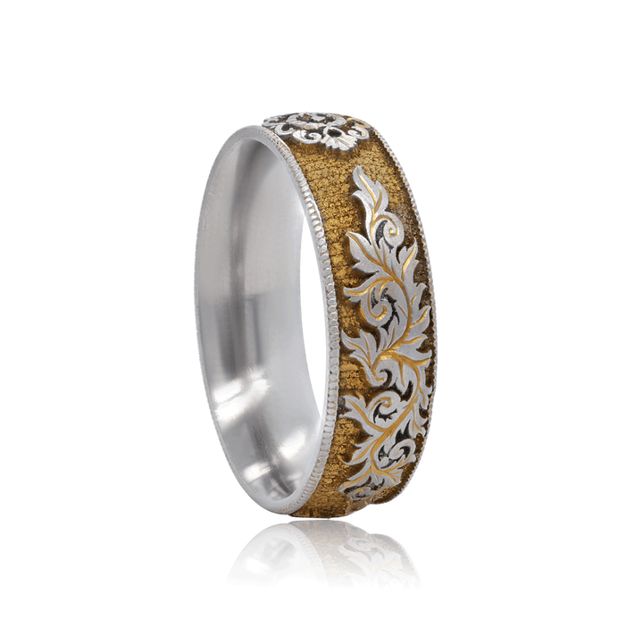 Angled view of titanium ring with gilded gold finish, detailed lock and scroll engraving, and intricate craftsmanship, displayed against a white background.
