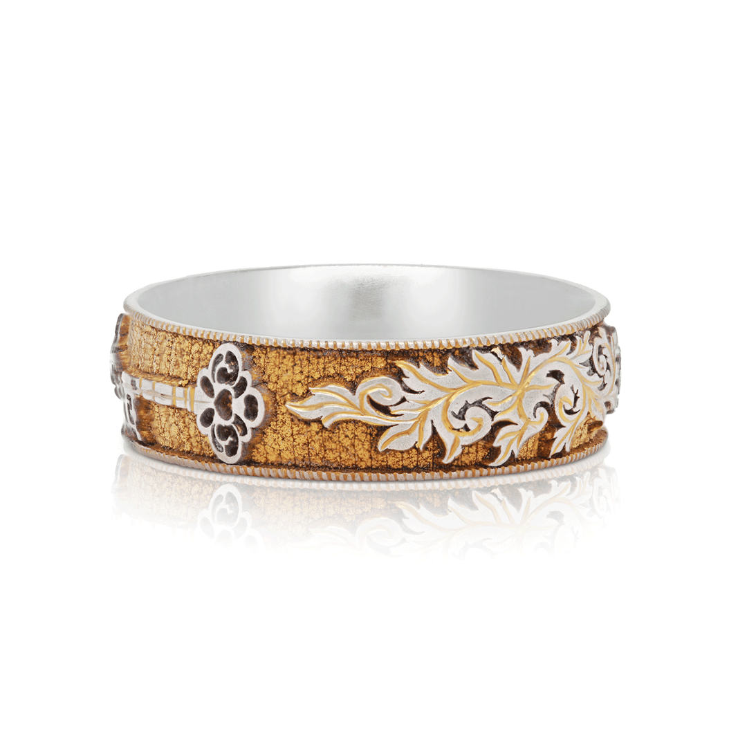 Shot of Gilded Gate titanium ring, highlighting gold anodized finish and symbolic key design, displayed on a white background.