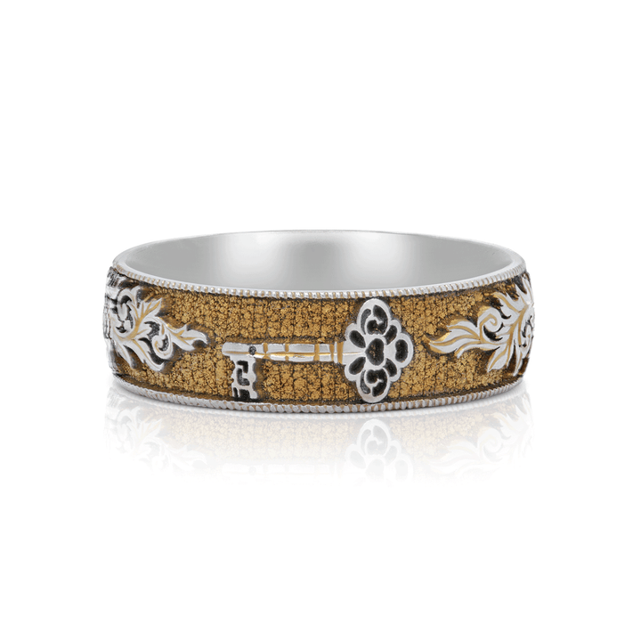 Front view of gold anodized titanium ring with hand-engraved lock and scrollwork, size 6.5, set on a white background.