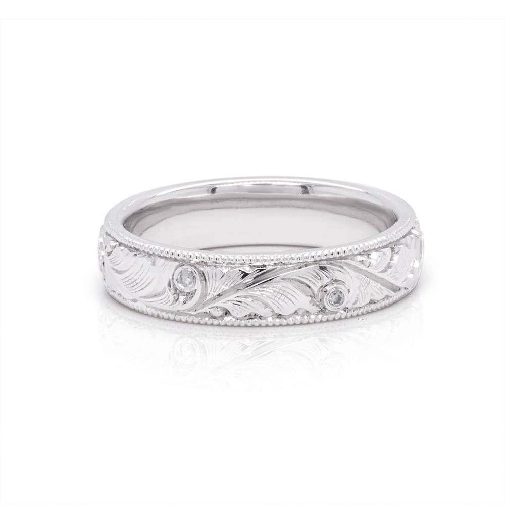 Polished platinum wedding band with intricate hand-engraved scrollwork and a mirror finish, highlighting the craftsmanship