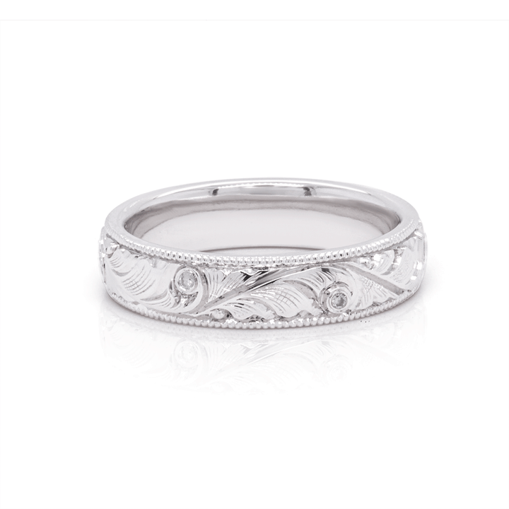 Polished platinum wedding band with intricate hand-engraved scrollwork and a mirror finish, highlighting the craftsmanship
