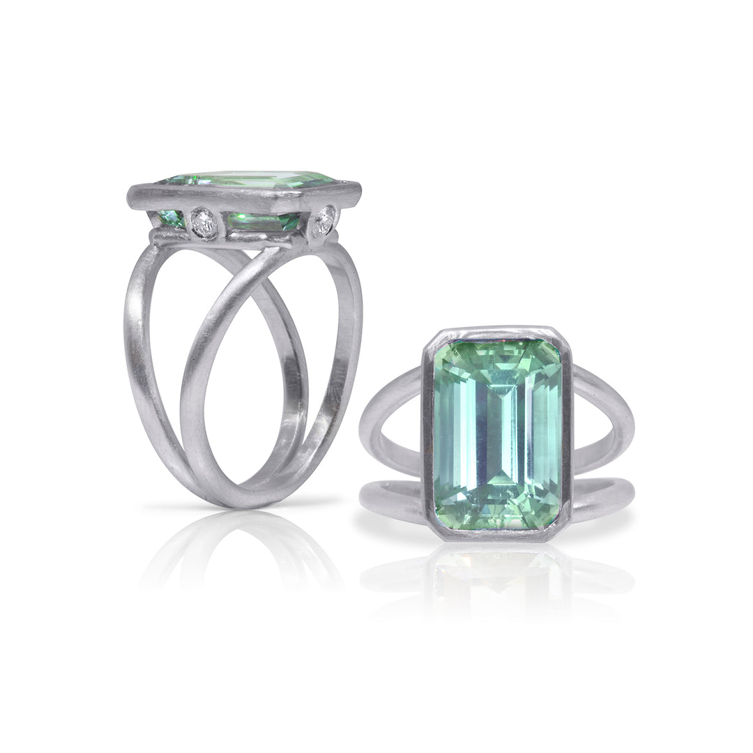 White gold split shank statement ring. Emerald cut aquamarine center stone. Aquamarine light blue-green hue.